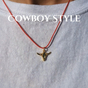 Gold bull skull pendant necklace on a red cord, showcasing a trendy cowboy style.