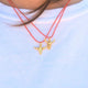 Minimalist gold bull head necklace on a bright red cord, perfect for adding a boho cowboy flair.