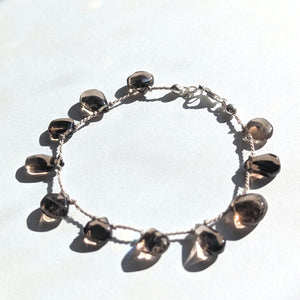 Close-up of a smokey quartz gemstone bracelet, emphasizing its subtle neutral tones.