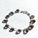 Close-up of a smokey quartz gemstone bracelet, emphasizing its subtle neutral tones.